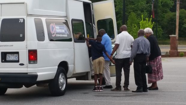 People near a white van with an open door. People near a white van with an open door.