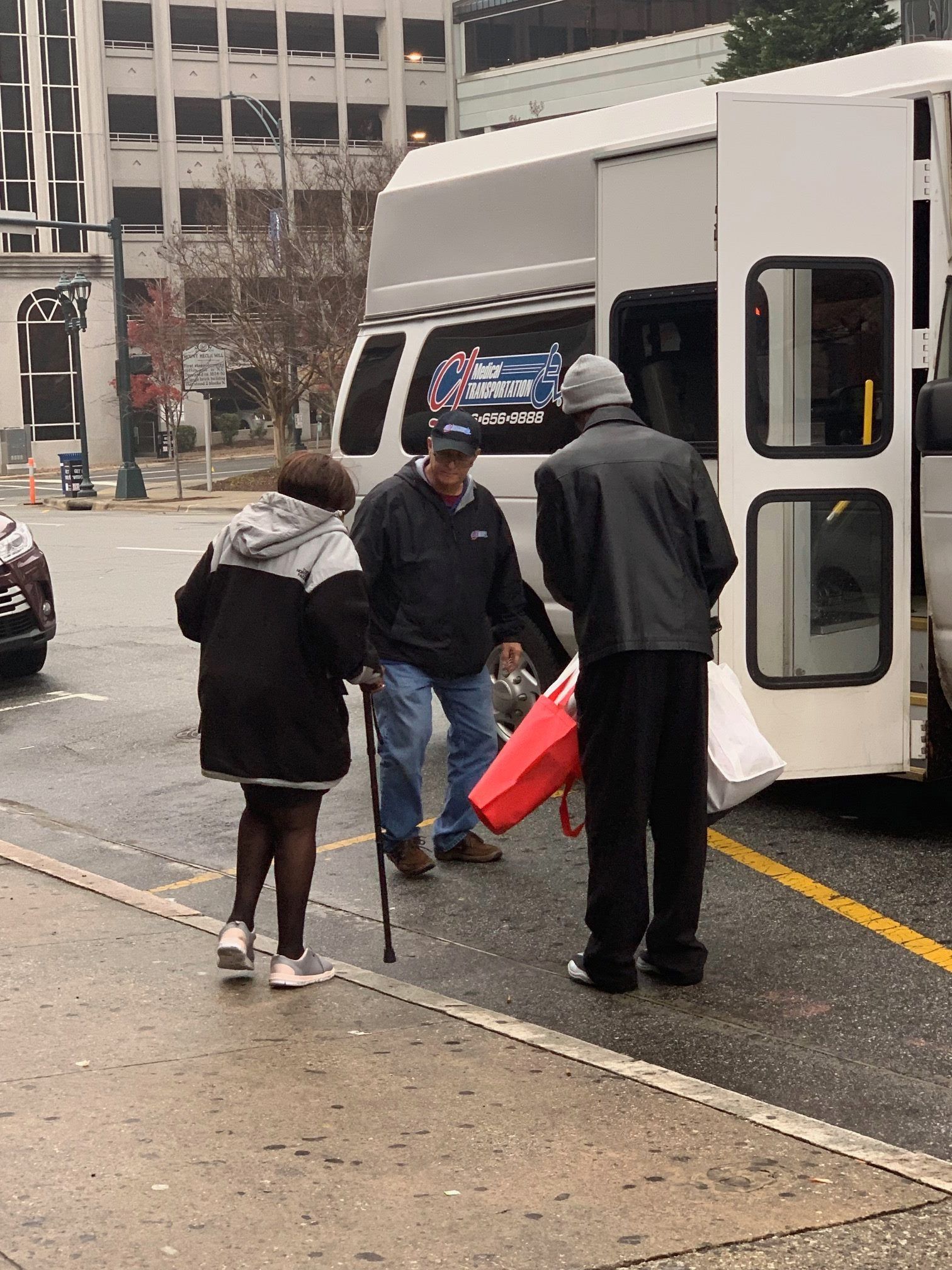 Three people stand near a parked transit van.