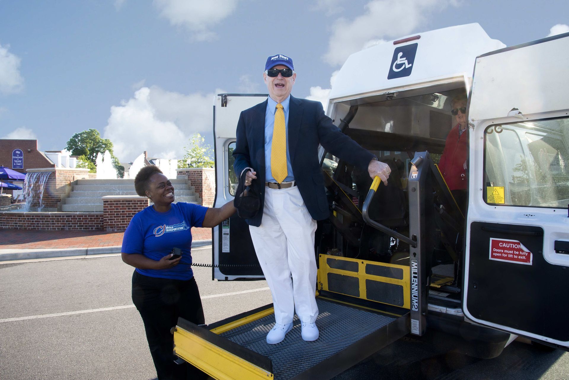 Man exiting accessible van with assistance.