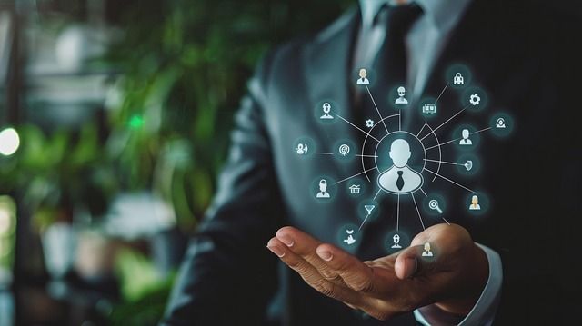 Man in suit holds out hand with glowing digital network around a person icon.