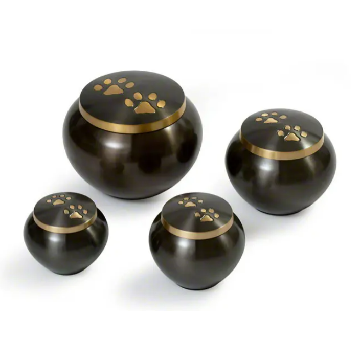 Four bronze pet urns with paw print details on white background.