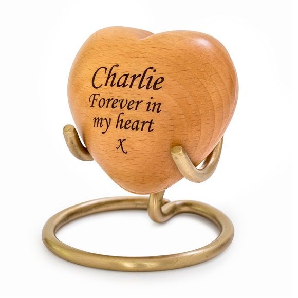 Heart-shaped wooden urn on a gold-colored stand, engraved with