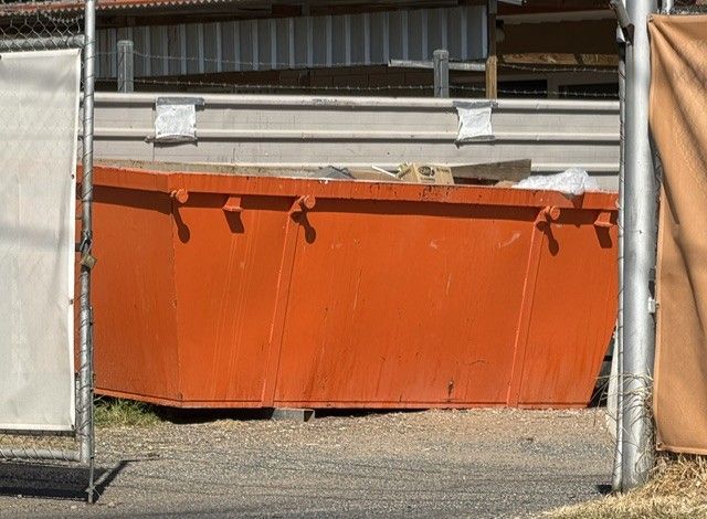 Orange construction barrier behind chain-link fencing at a work site — Alice Skip Hire in Alice Springs, NT