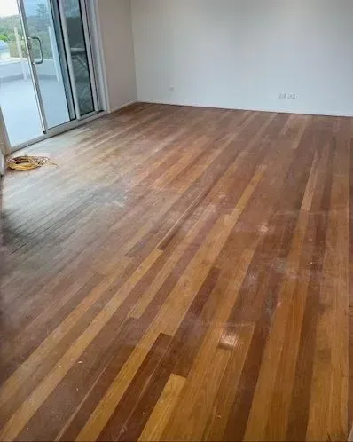 A Living Room With a Polished Wooden Floor and a Sliding Glass Door — Tweed Coast Cork & Timber Floors In Tweed Heads, NSW