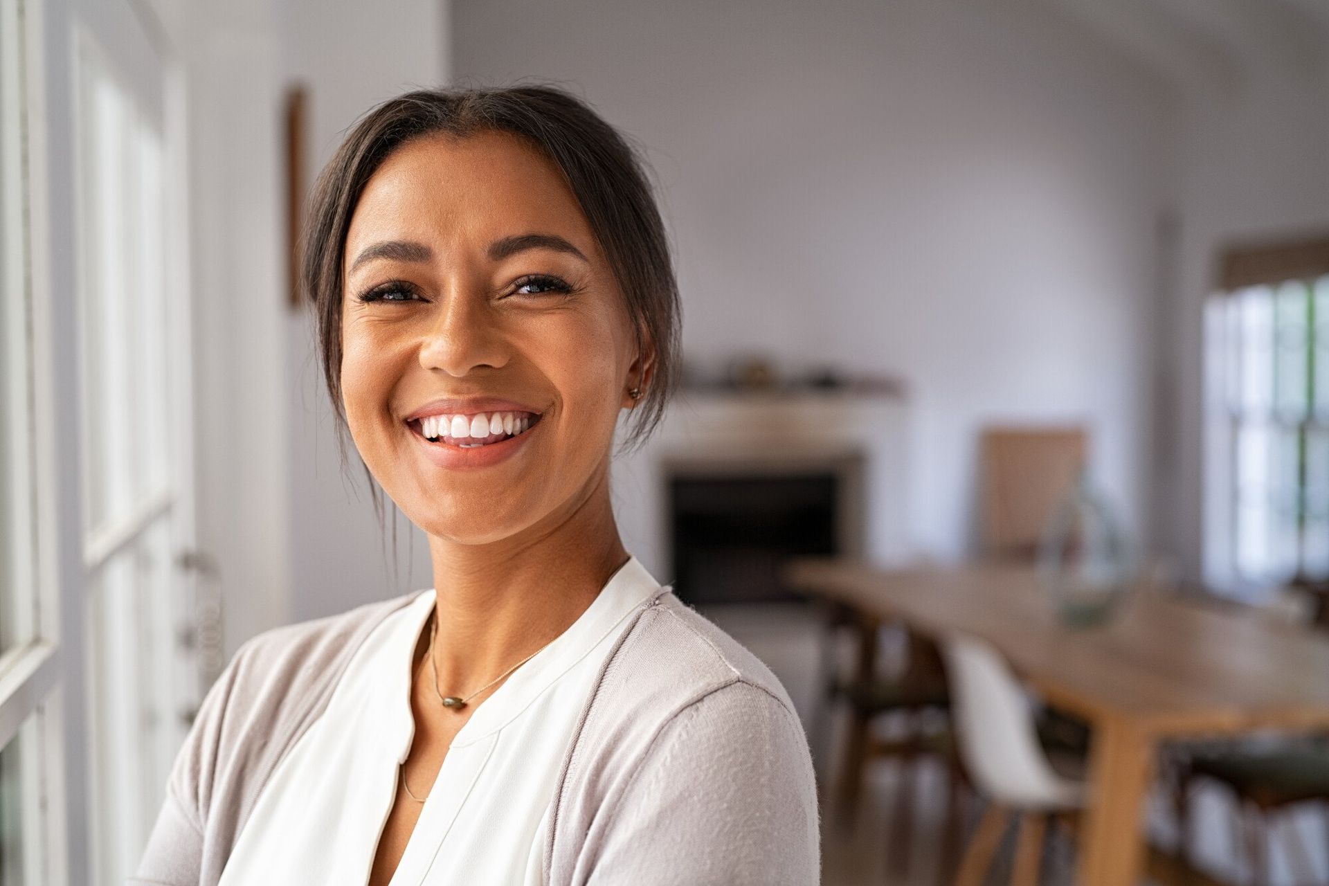 a woman is smiling while standing in front of a window
