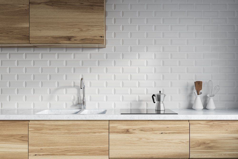 A Kitchen with White Brick Tiles, Wooden Cabinets, a Sink and A Stove Top Oven — Bestbuy Kitchens in Yandina, QLD