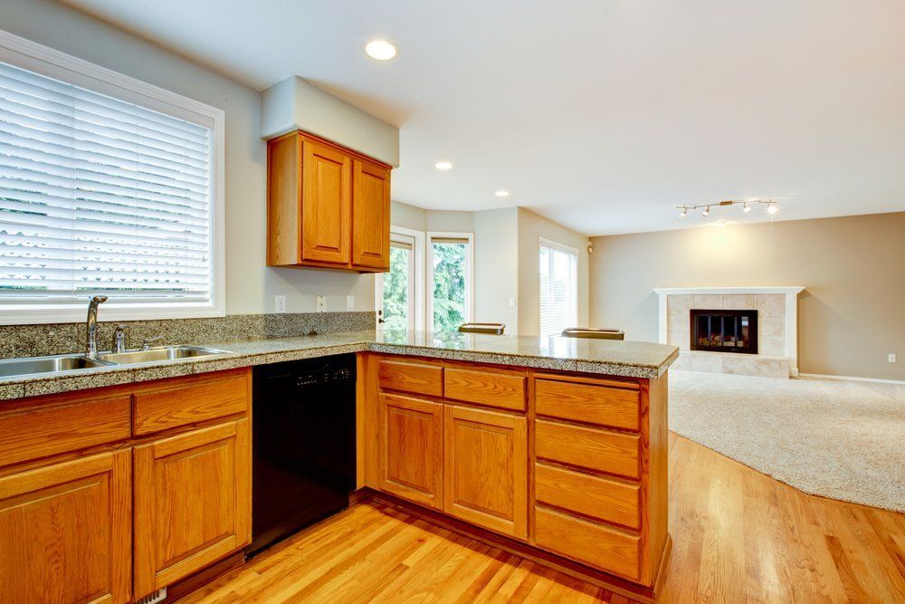 A Kitchen with Wooden Cabinets, Granite Counter Tops, a Sink, and A Fireplace — Bestbuy Kitchens in Yandina, QLD