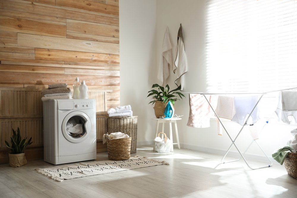 A Laundry Room with A Washing Machine and Drying Rack — Bestbuy Kitchens in Yandina, QLD