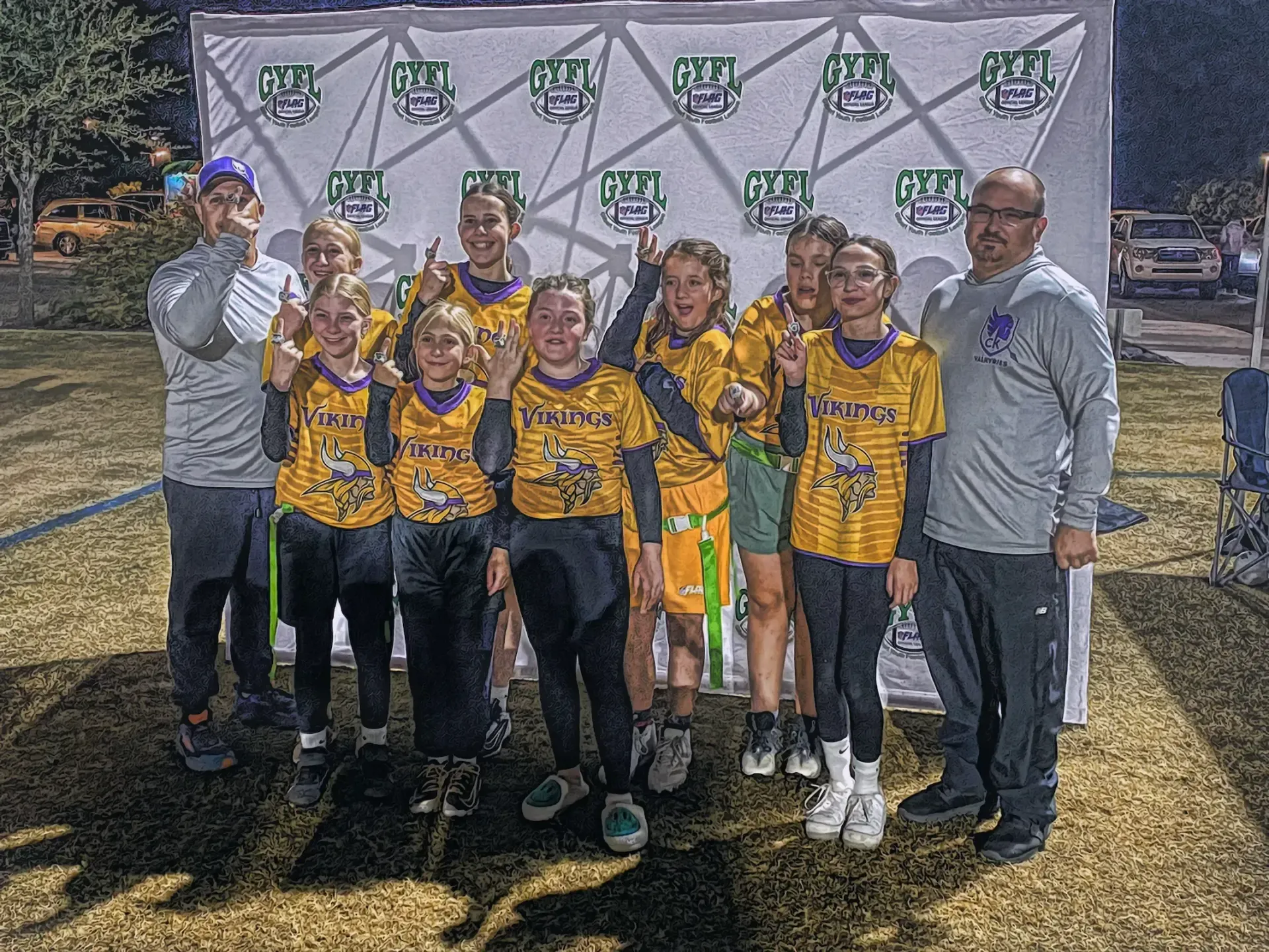 Youth soccer team posing with medals and banner outdoors after a tournament