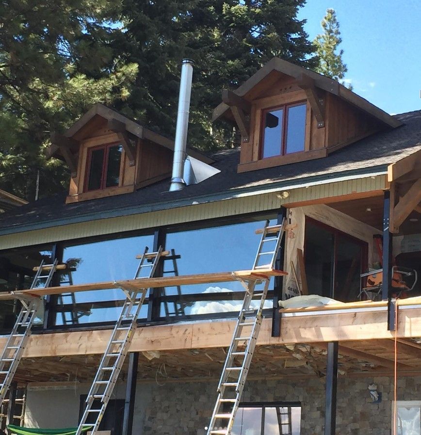 House under construction with ladders and scaffolding on the front porch