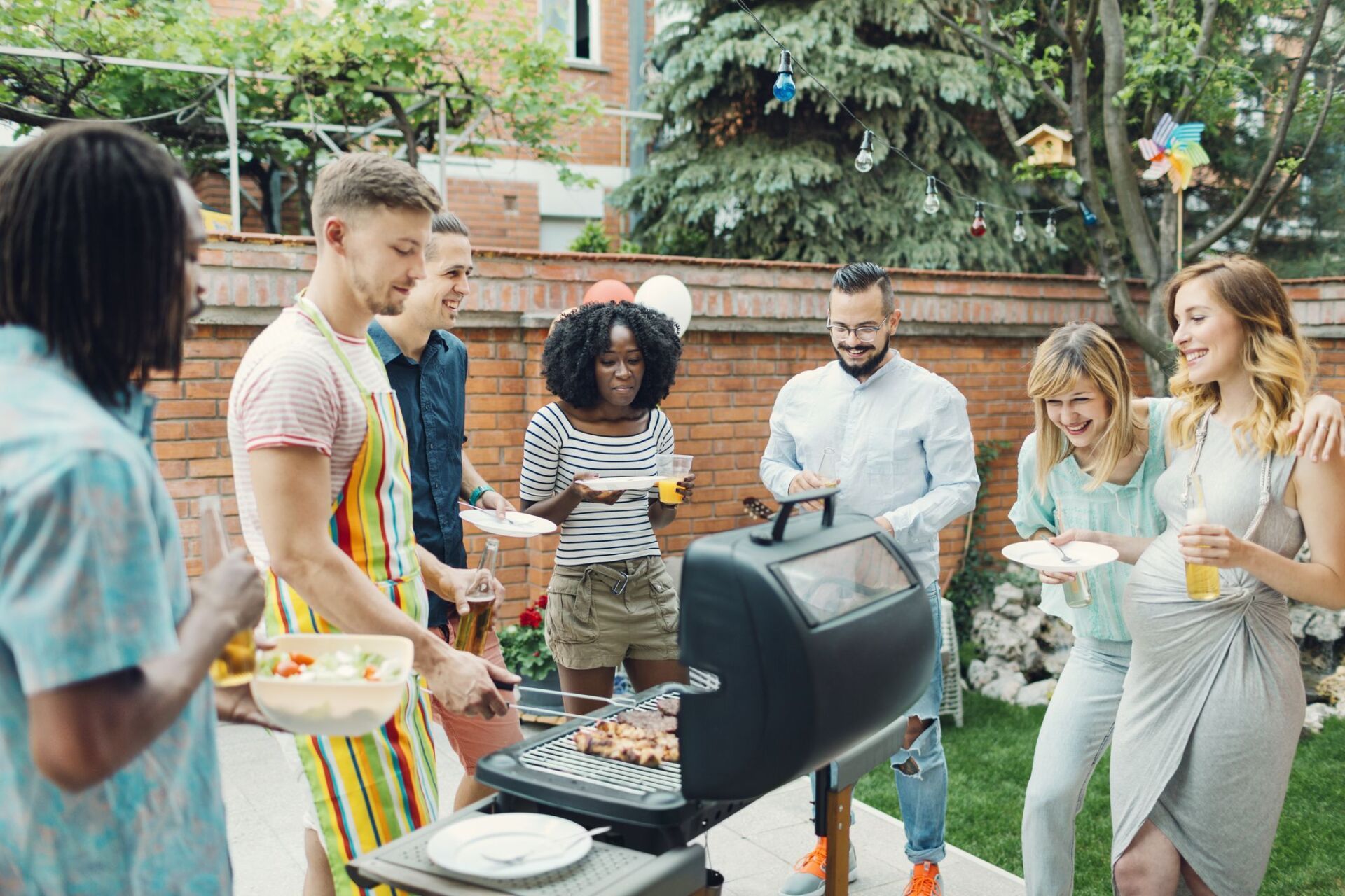 A group of people are having a barbecue in their backyard. - mosquito control