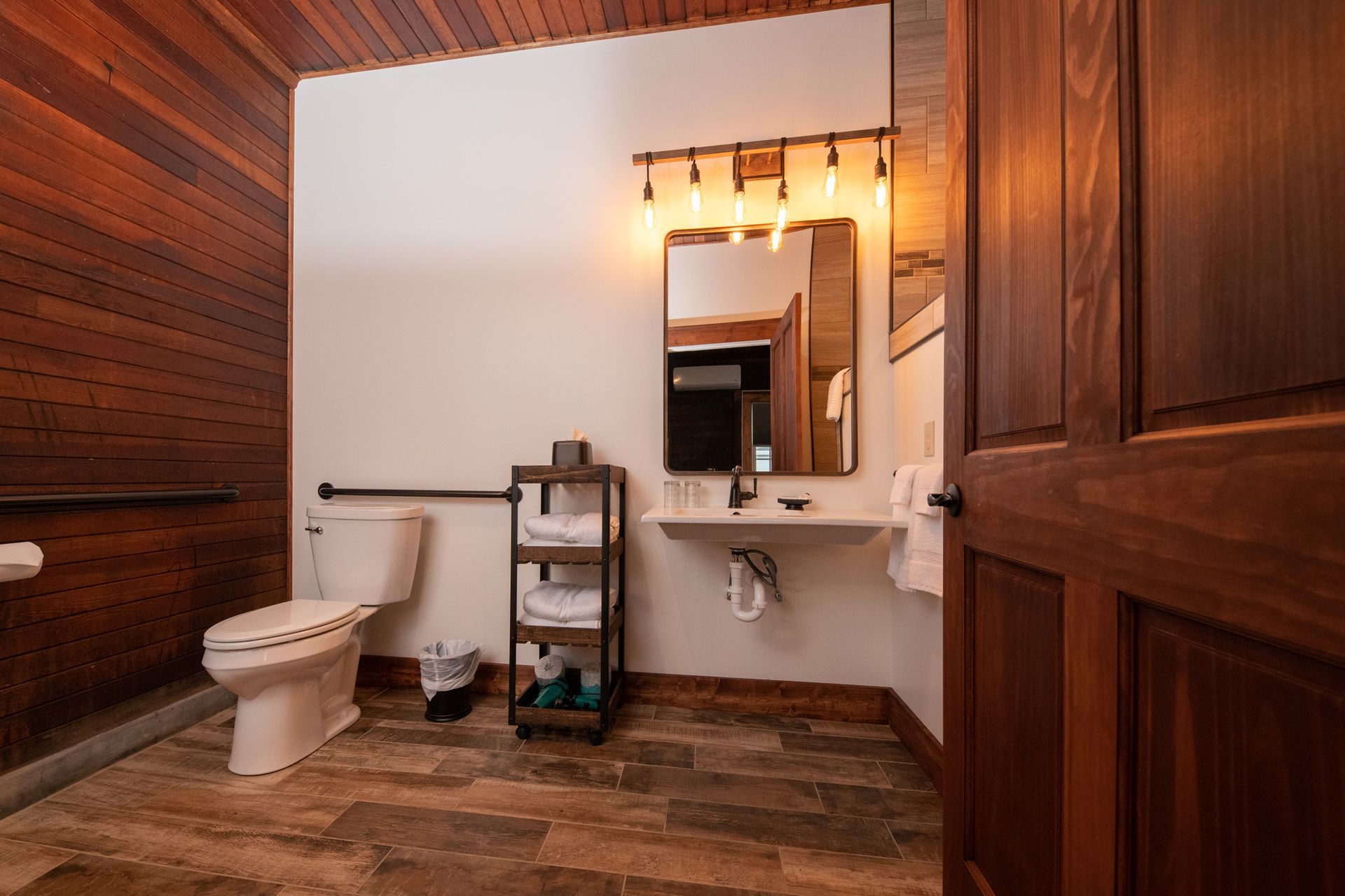 A bathroom with a toilet , sink and mirror.