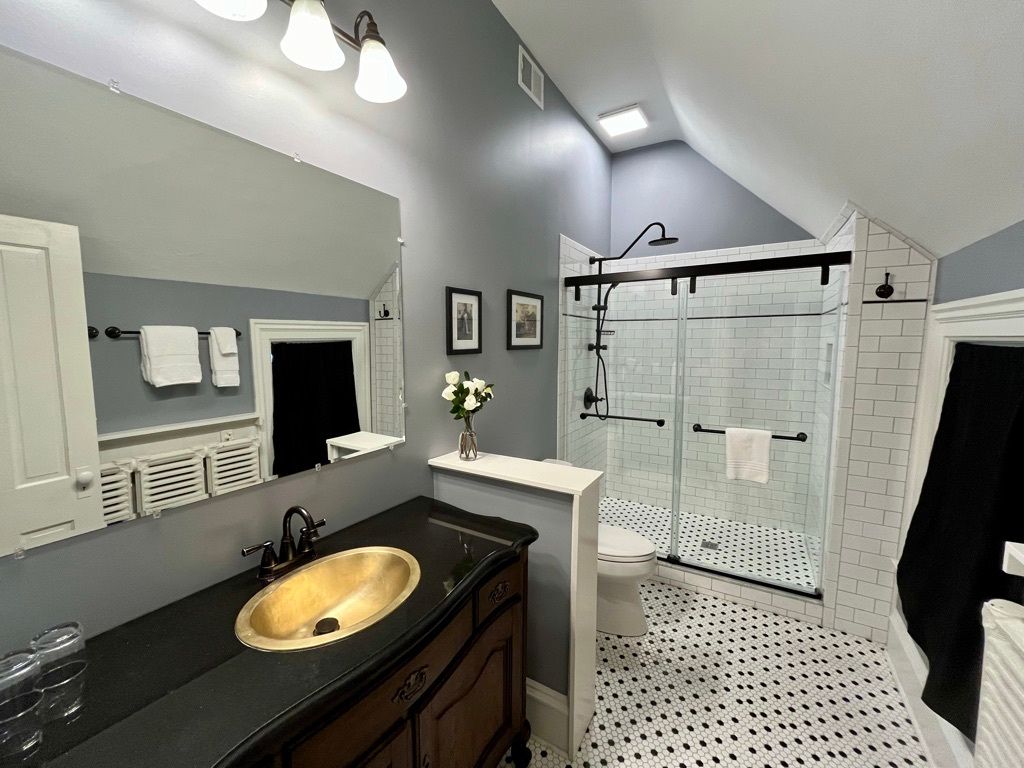 A bathroom with a sink , mirror , and shower.