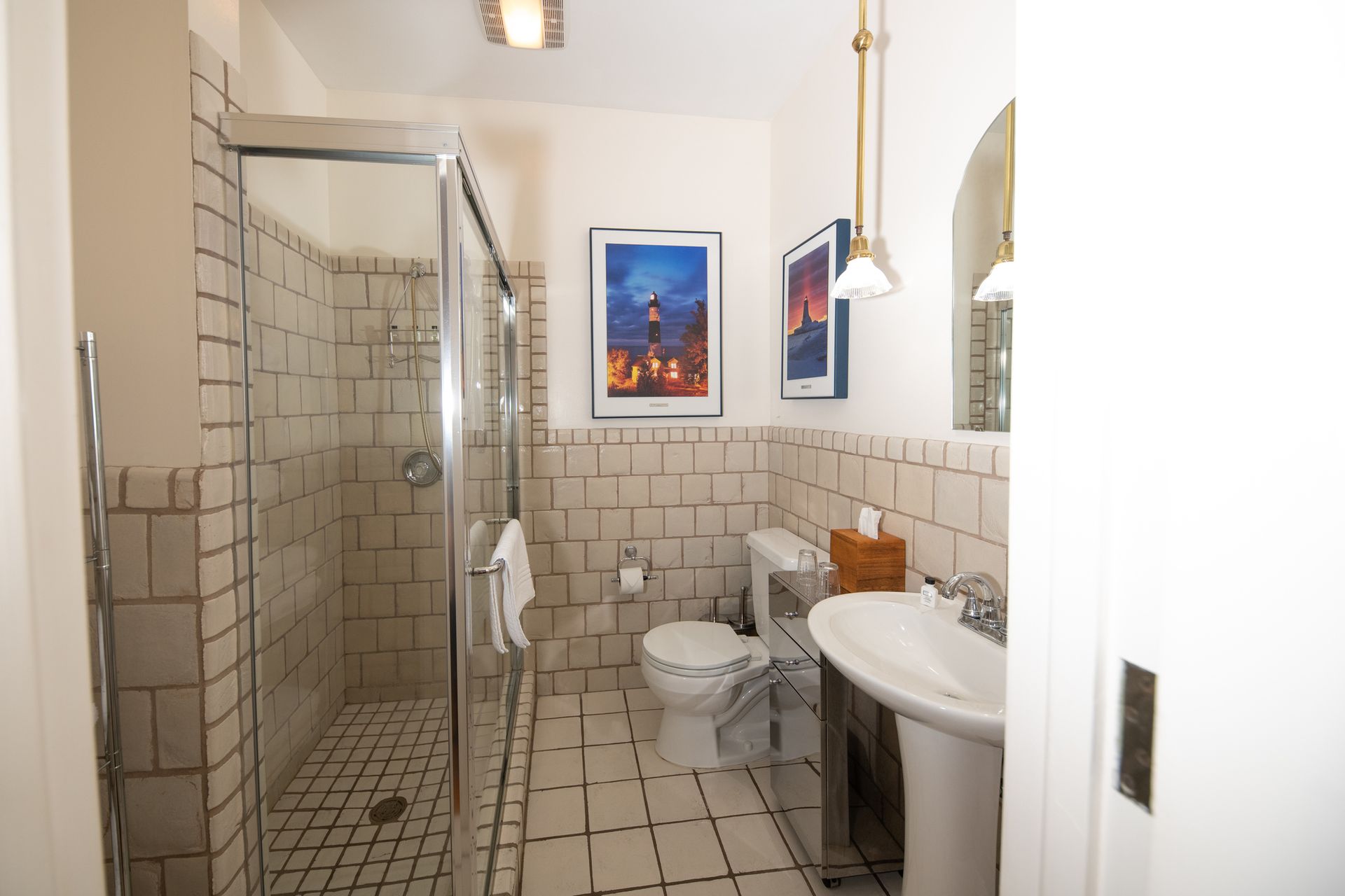 A bathroom with a toilet , sink , and walk in shower.