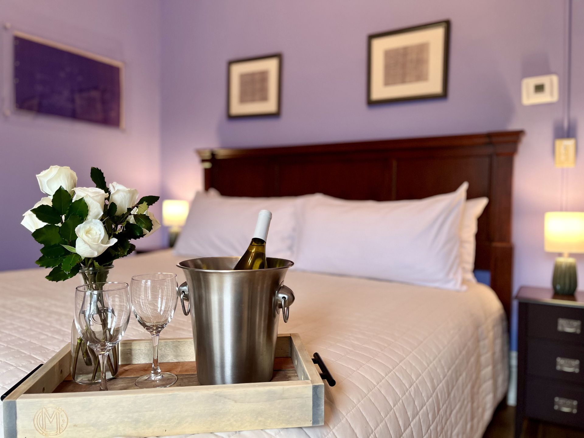 A bed with a bucket of wine and glasses on it