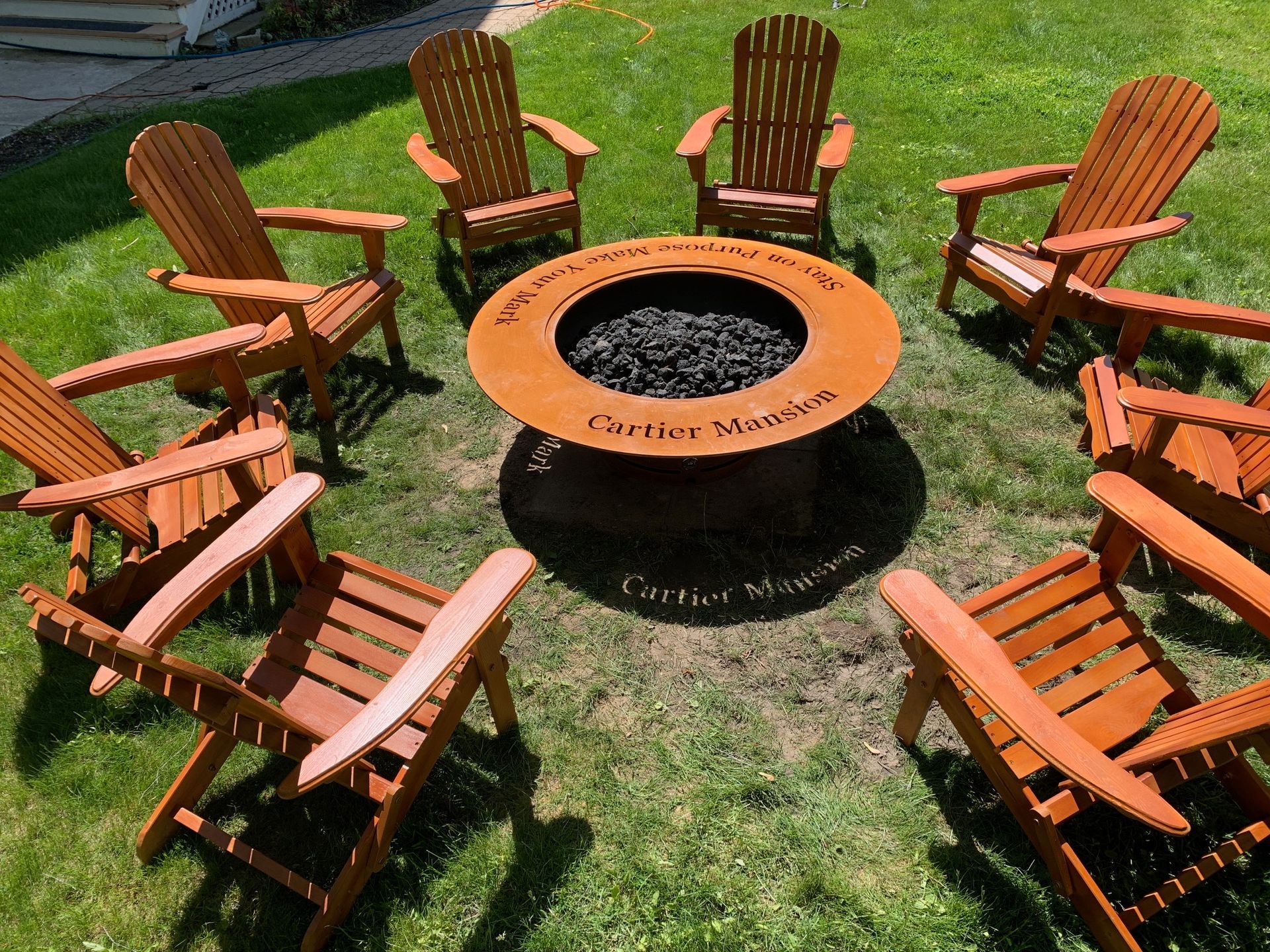 A group of wooden chairs are sitting around a fire pit.