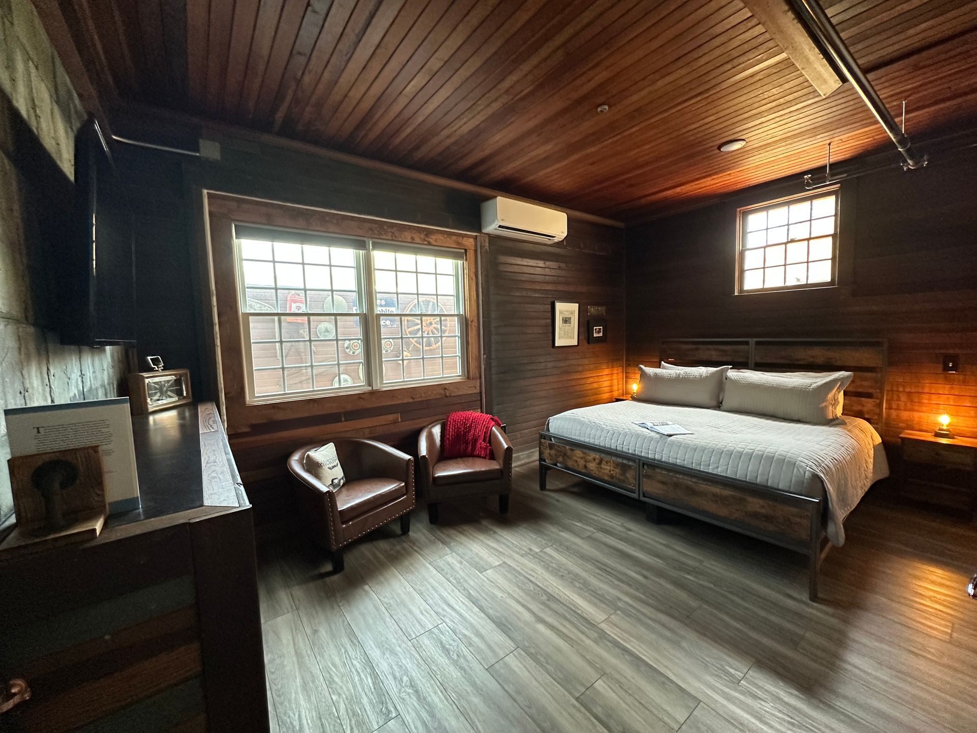 A bedroom with a bed , chairs , and a television.