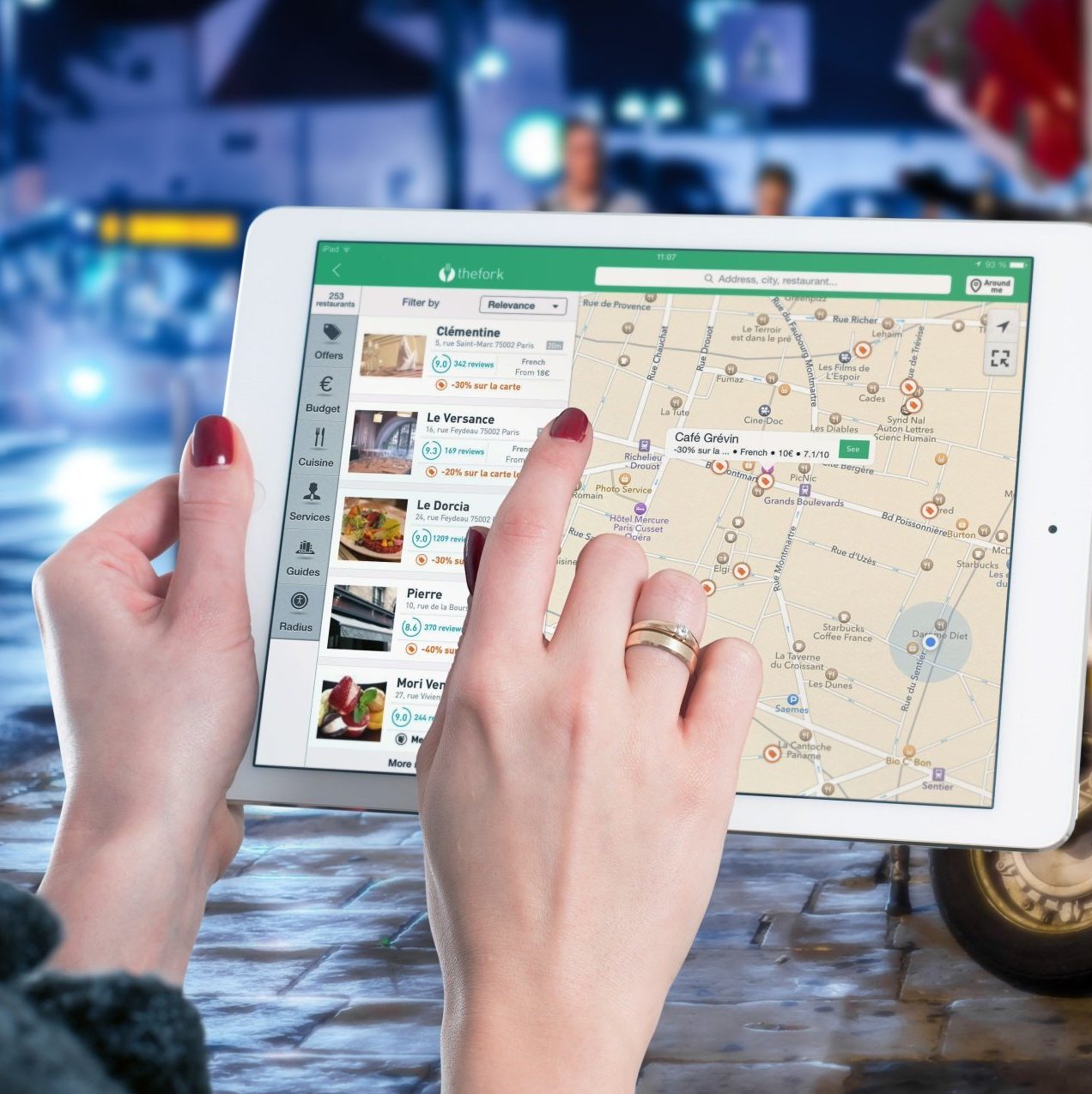 A person is holding a tablet with a map on it
