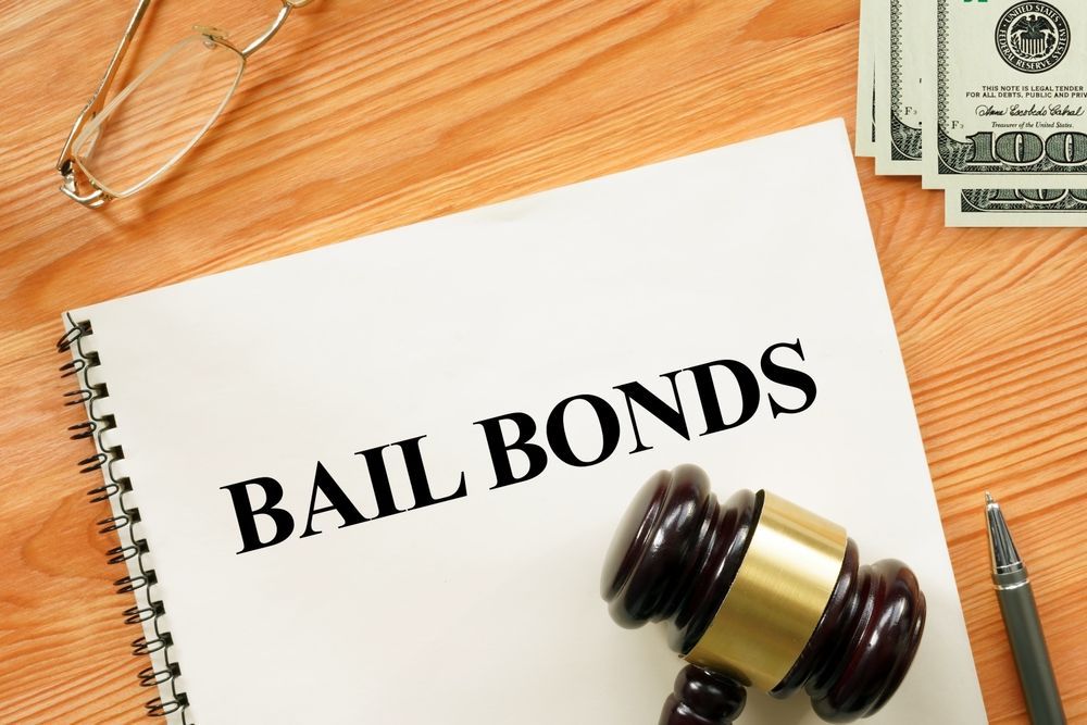 Bail bonds paperwork on a desk with gavel, pen, and cash in the corner.