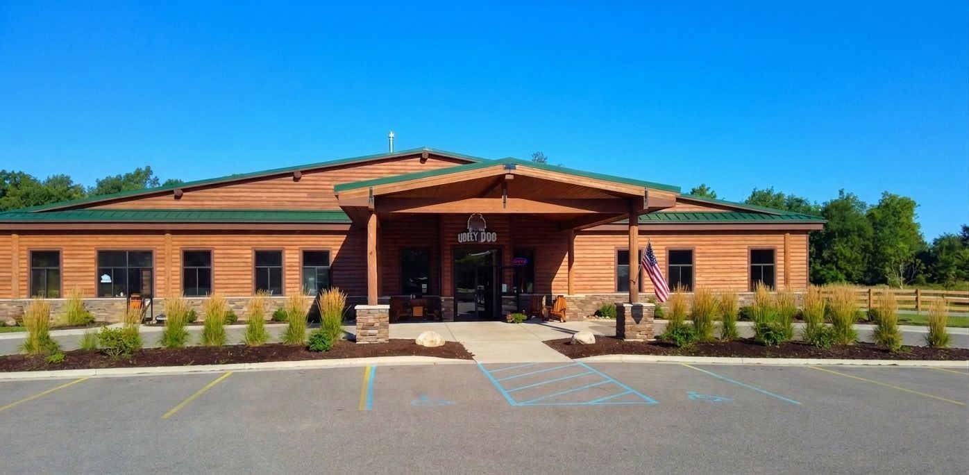 Single-story brick building with a covered entrance and parking lot in front