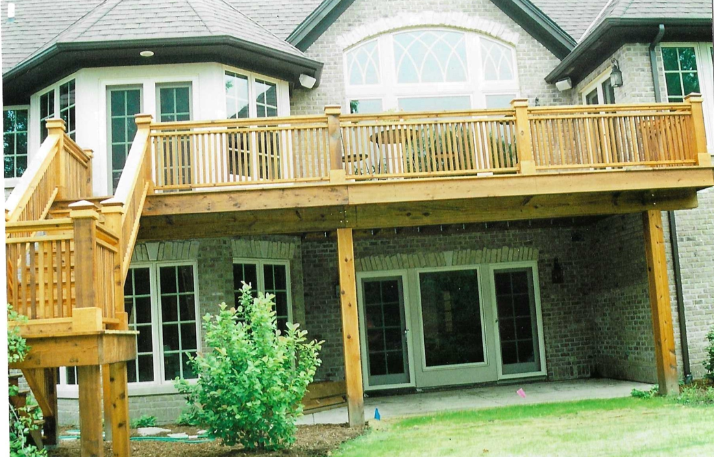 A large house with a wooden deck in front of it