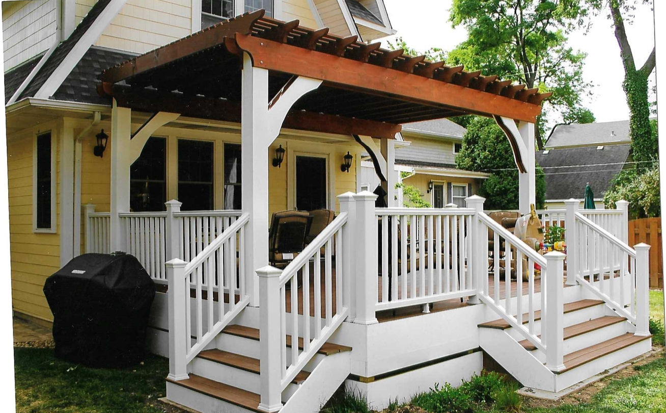 A yellow house with a white deck and stairs
