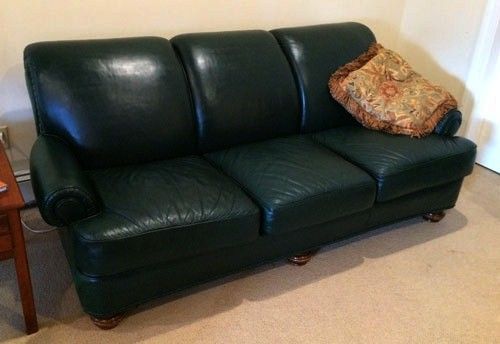 Green leather couch with a patterned pillow.