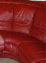 Red leather sofa, close-up, showing cushions and seams.