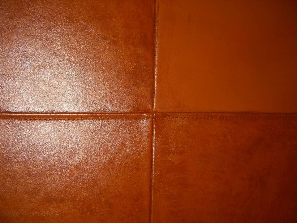 Close-up of brown leather upholstery with stitched seams.