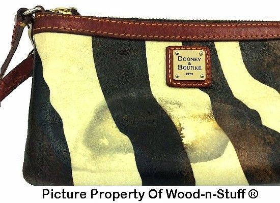 Zebra-striped Dooney & Bourke clutch with brown leather trim and staining. Gold hardware and logo tag.