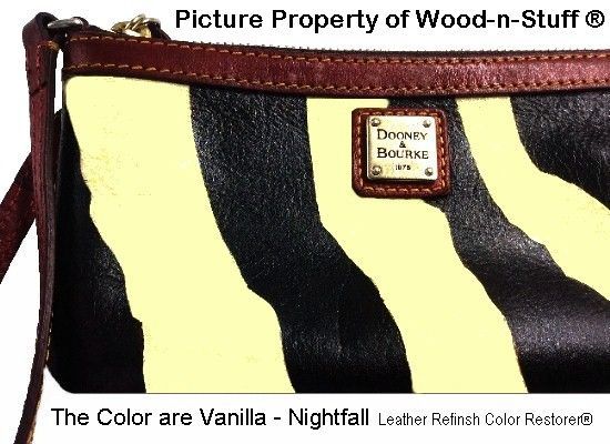 Zebra-striped Dooney & Bourke clutch with a leather wrist strap and trim. Colors: vanilla and black.