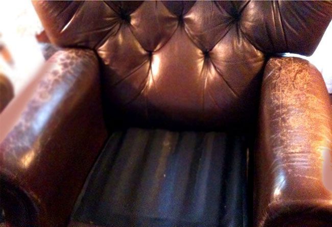 Brown leather armchair with button tufting, worn finish.
