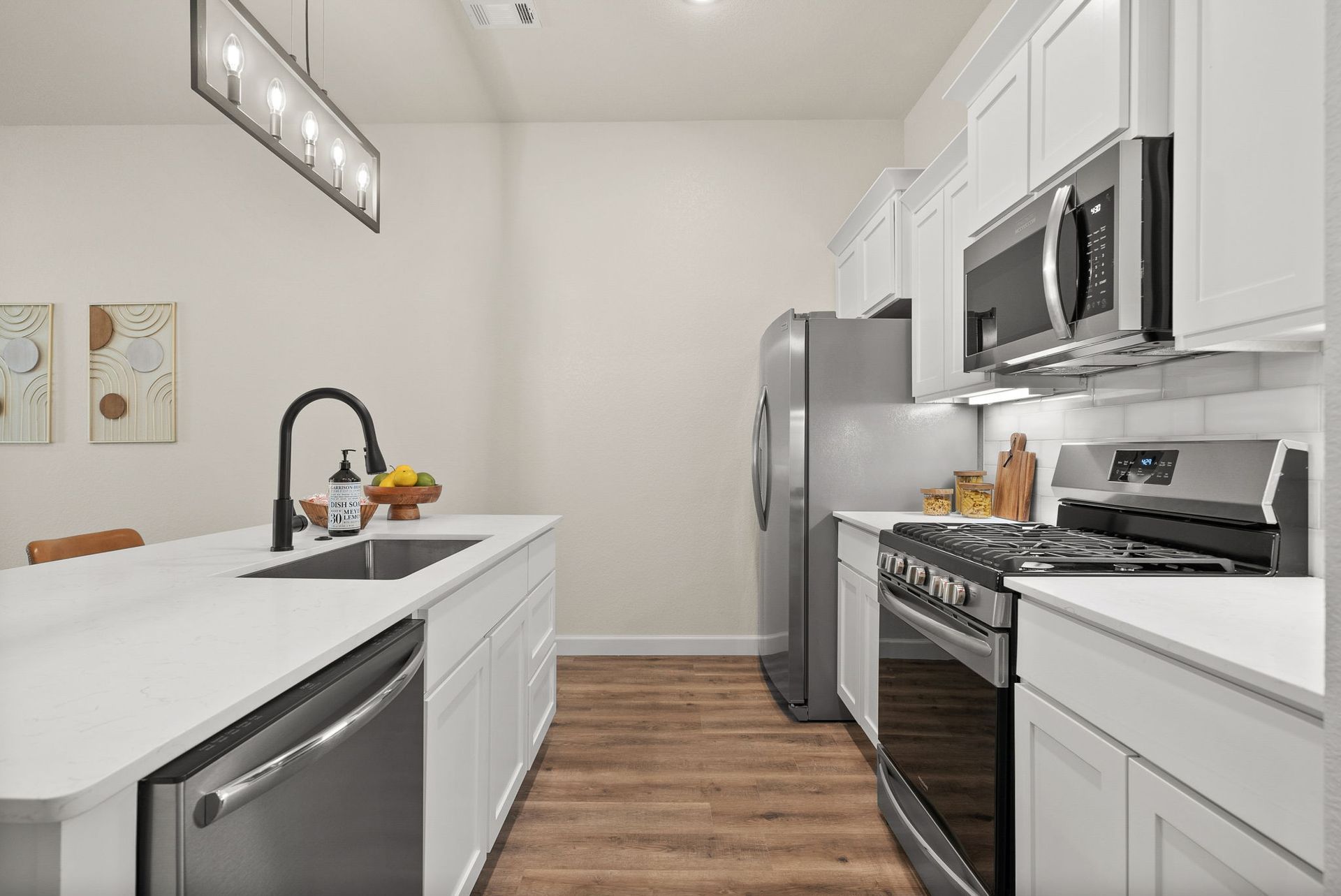 A kitchen with stainless steel appliances and white cabinets.