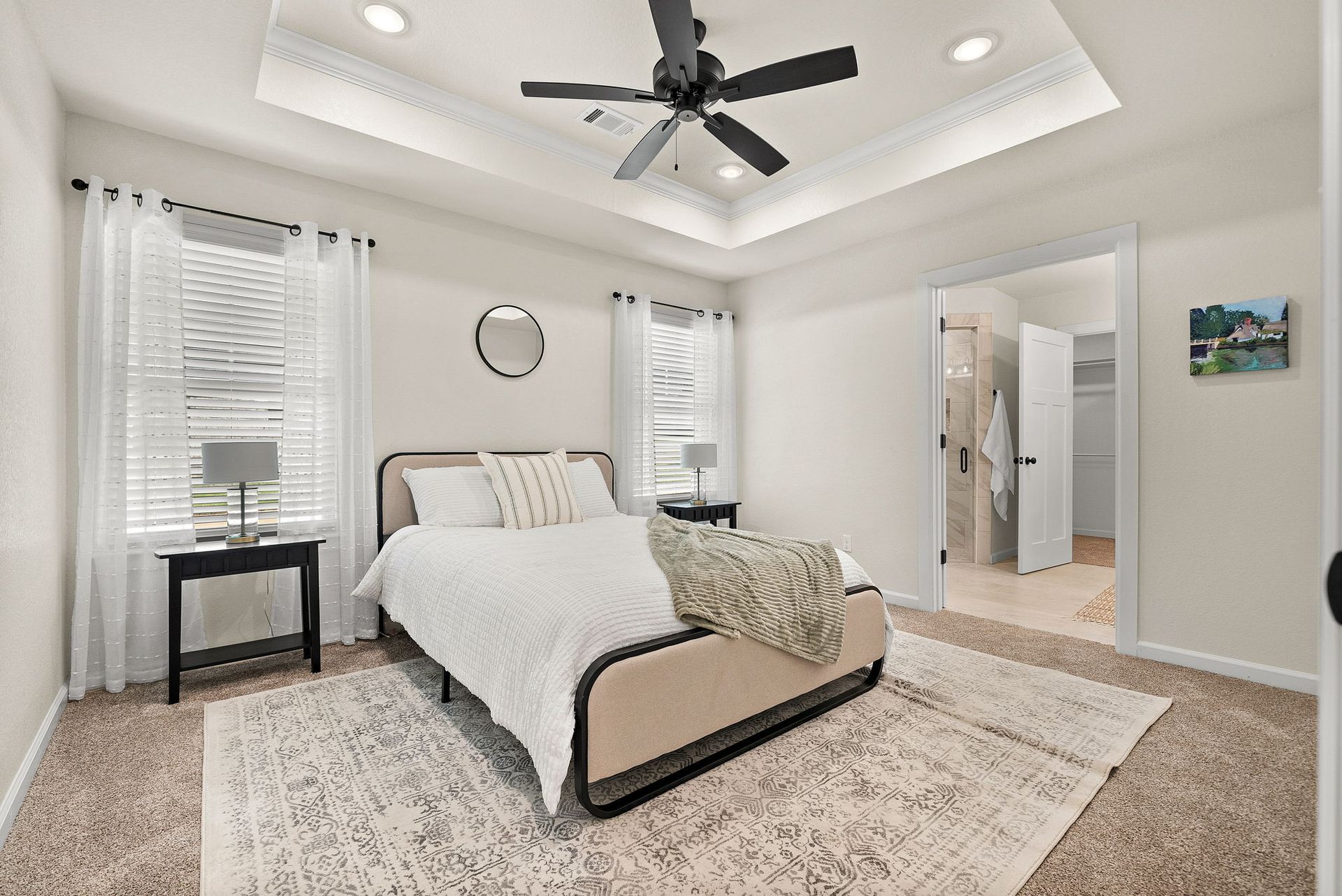 A bedroom with a bed and a ceiling fan.