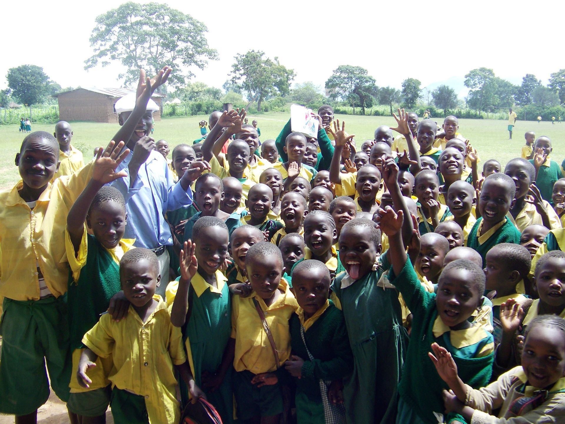 A group of children are posing for a picture with their hands in the air