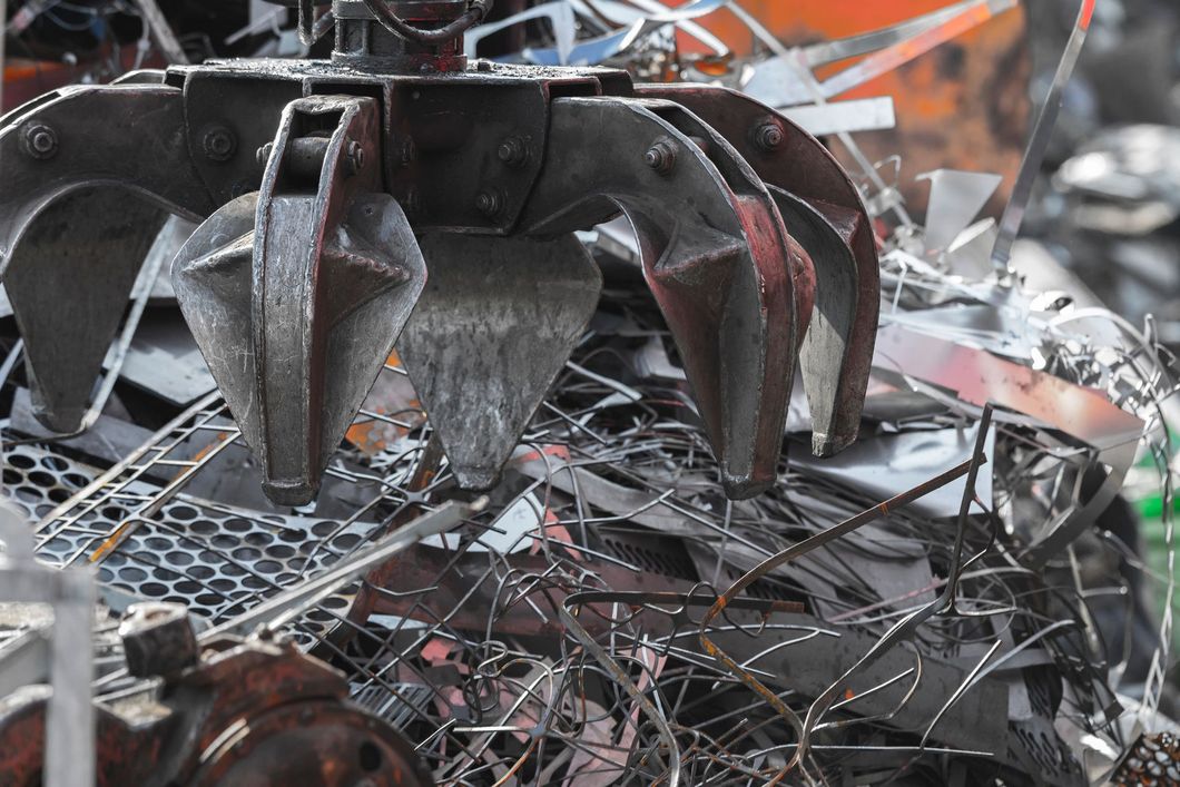 Relitti metallici contorti con un pezzo di veicolo annerito tra detriti e fili aggrovigliati