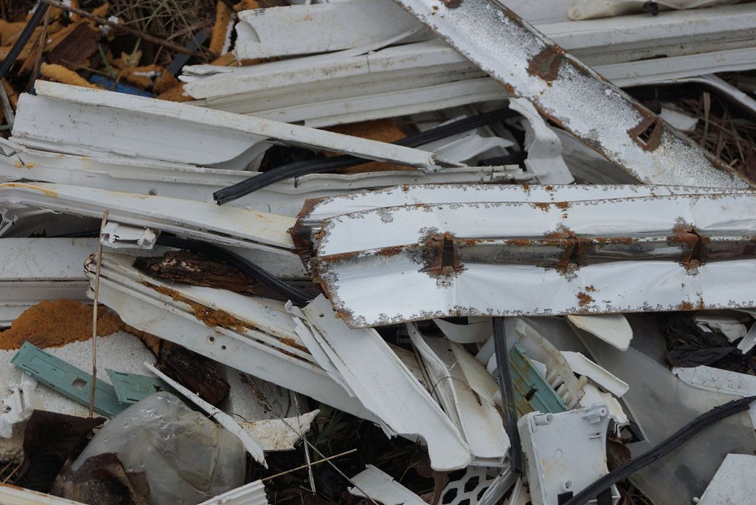 Cumuli di metallo bianco rotto e detriti con ruggine e sporcizia sparsi ovunque