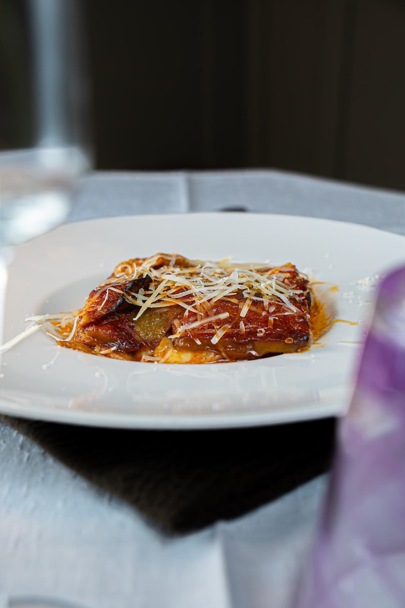 Piatto di pasta con salsa di pomodoro e formaggio grattugiato, su un tavolo di ristorante