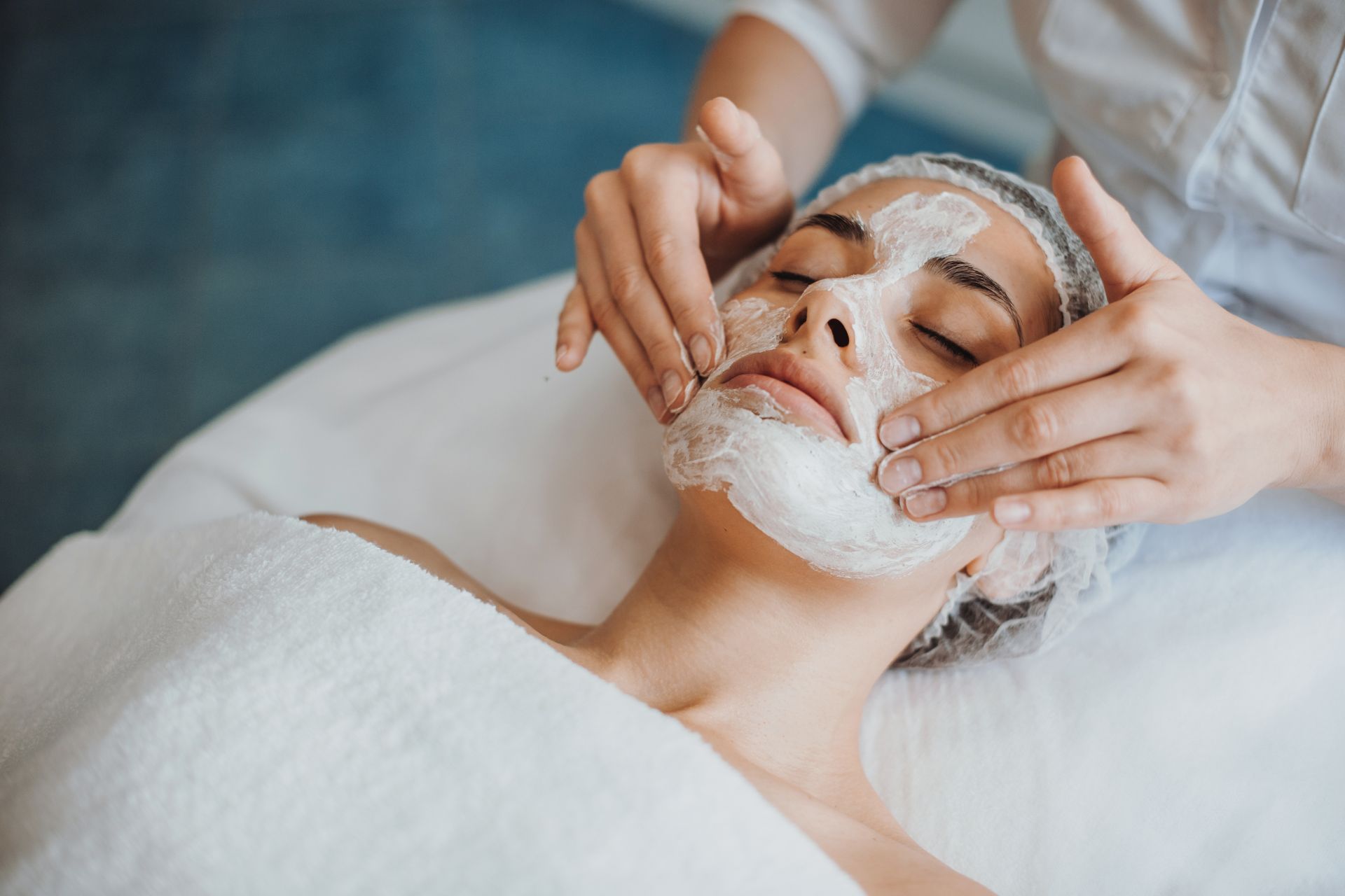 Person receiving a facial treatment with cleansing foam in a spa setting