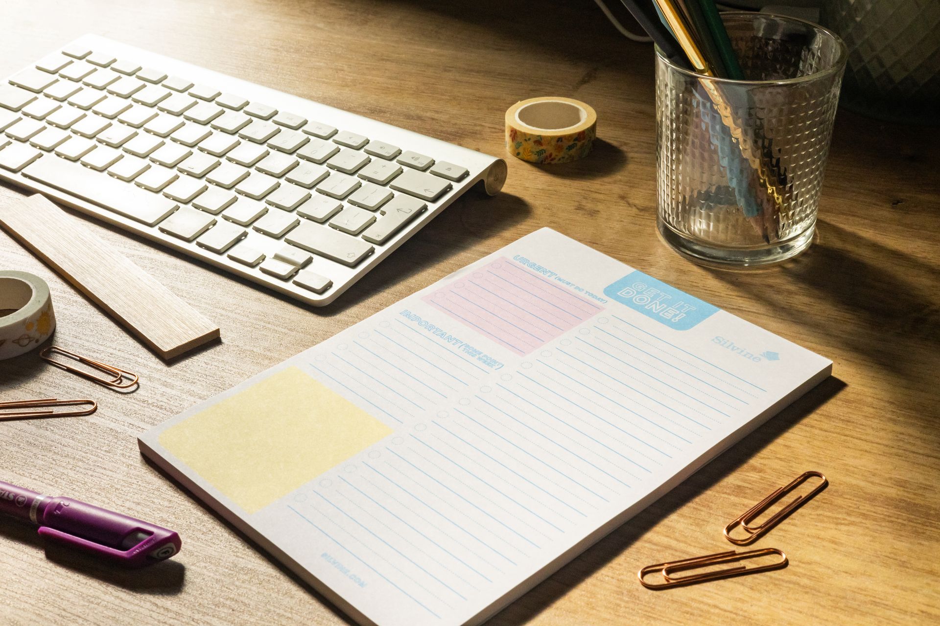 A to do pad on a desk with keyboard and stationery items