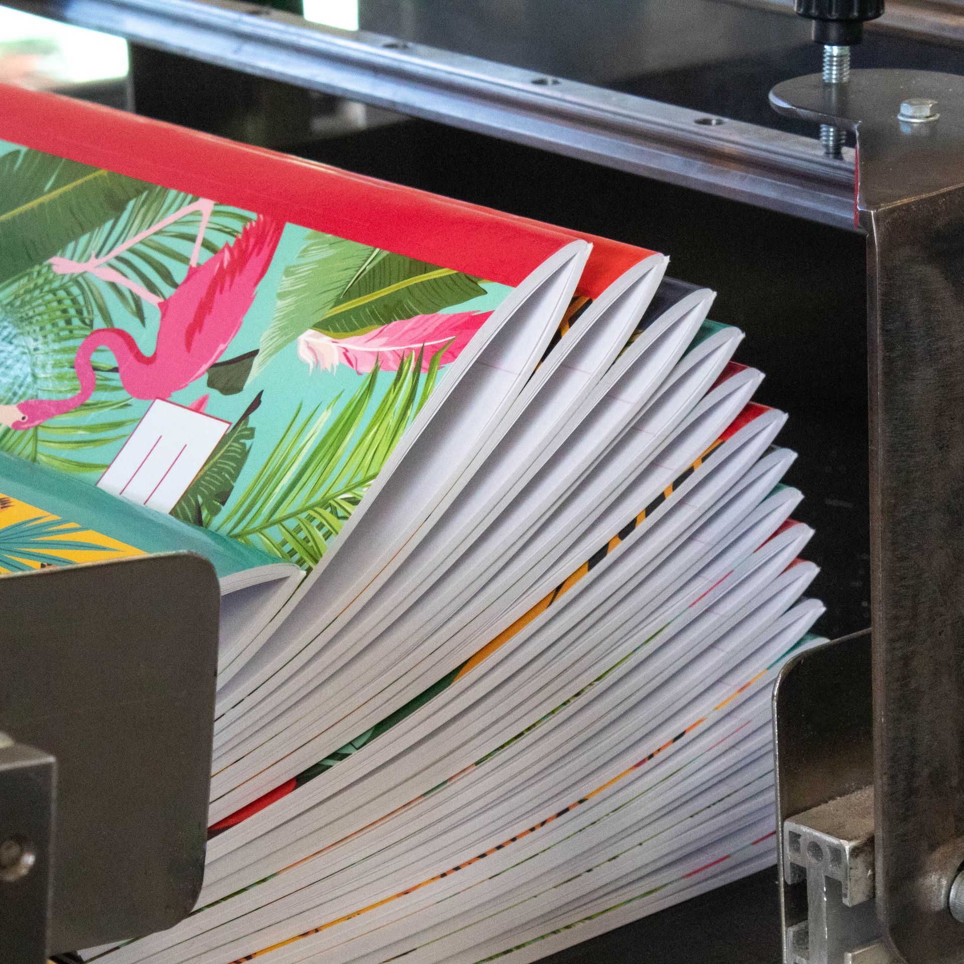 Exercise books being made on a machine.