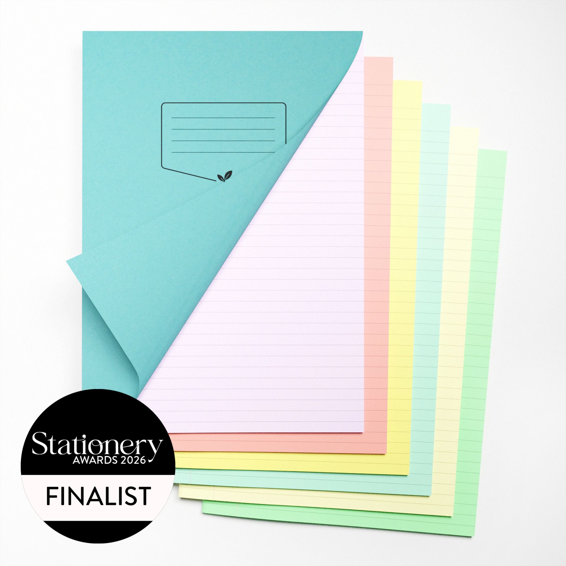 A variety of tinted paper exercise books on a white background, showing different coloured inner sheets. Colours on show are purple, pink, yellow, blue, cream and green. Image has the official Stationery Awards 2026 finalist badge on it.