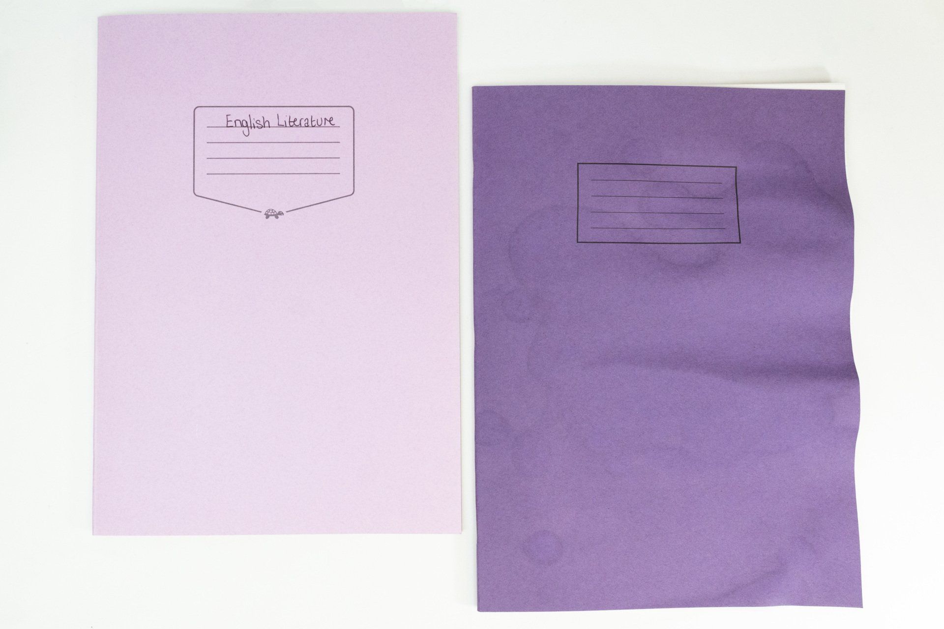 Image of Tough Shell Exercise Book and normal Exercise Book on white background with water spilled on the books.