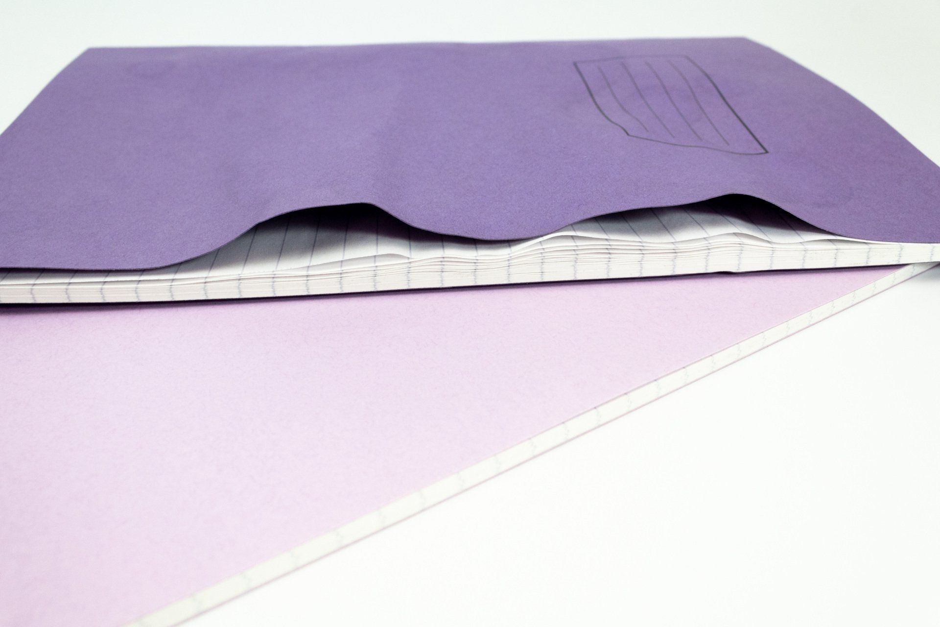 Image of Tough Shell Exercise Book and normal Exercise Book on white background with water spilled on the books.