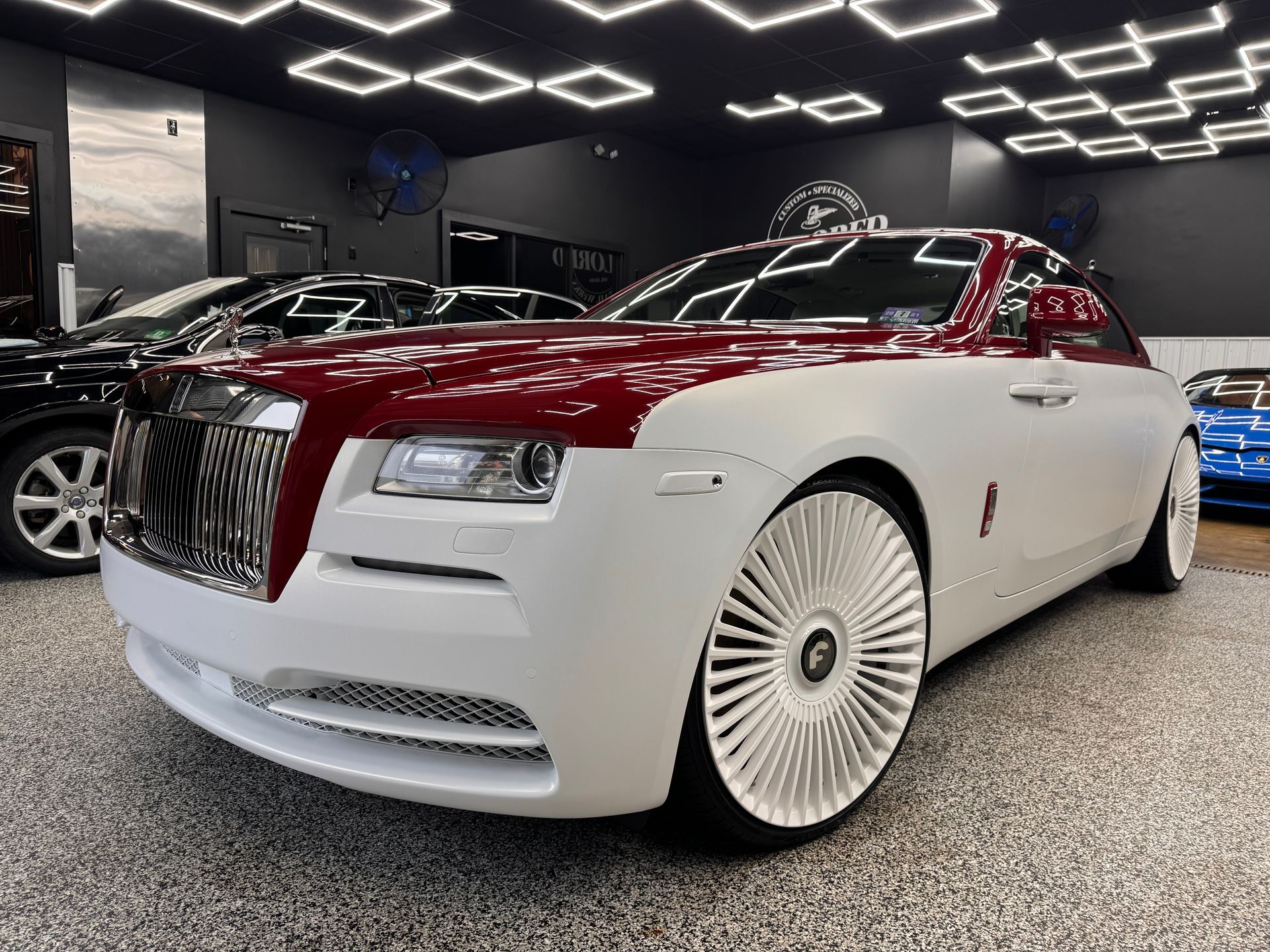 Red and white luxury convertible car displayed in a showroom
