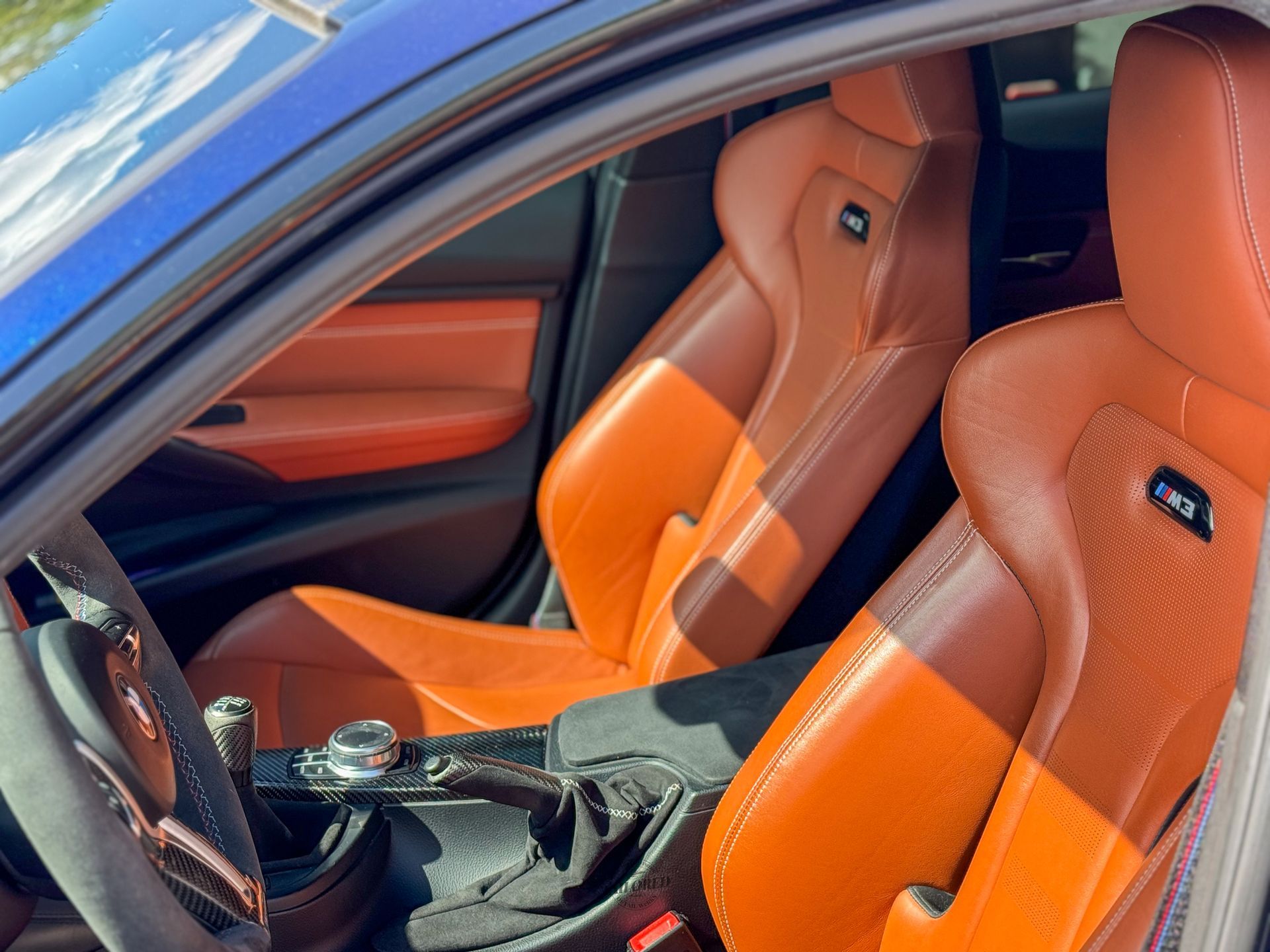 Orange leather sports car interior with bucket seats and manual gear shift