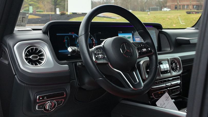 Car interior with steering wheel, dashboard, and vents, viewed from the passenger side.