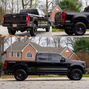 Black lifted pickup truck shown from rear and side in a driveway, with brick house and trees in background