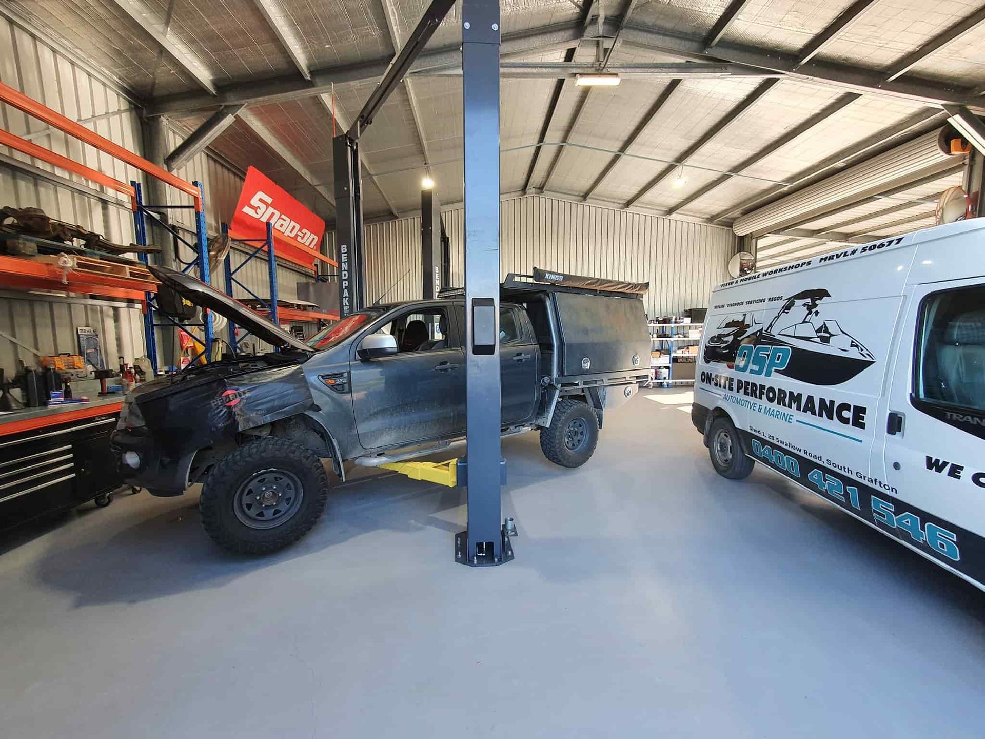 A Truck is Sitting on a Lift in a Garage Next to a Van — OSP Automotive & Marine In Grafton, NSW