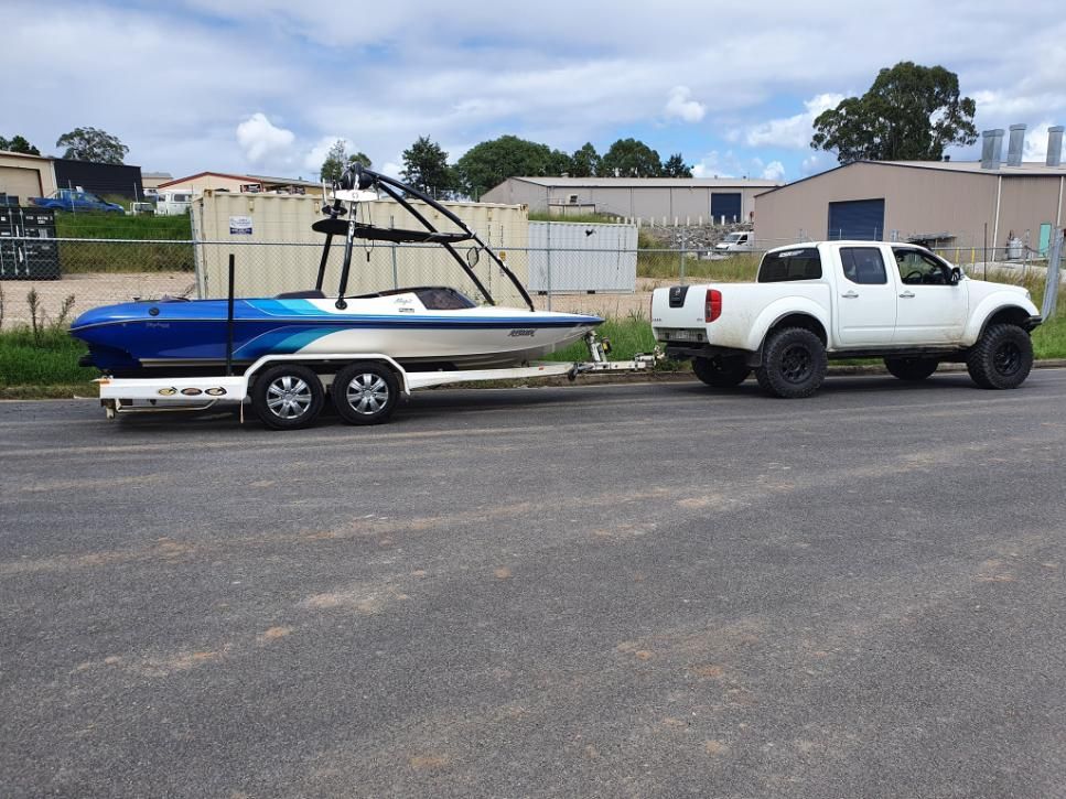 A White Truck is Towing a Boat on a Trailer — OSP Automotive & Marine In Grafton, NSW